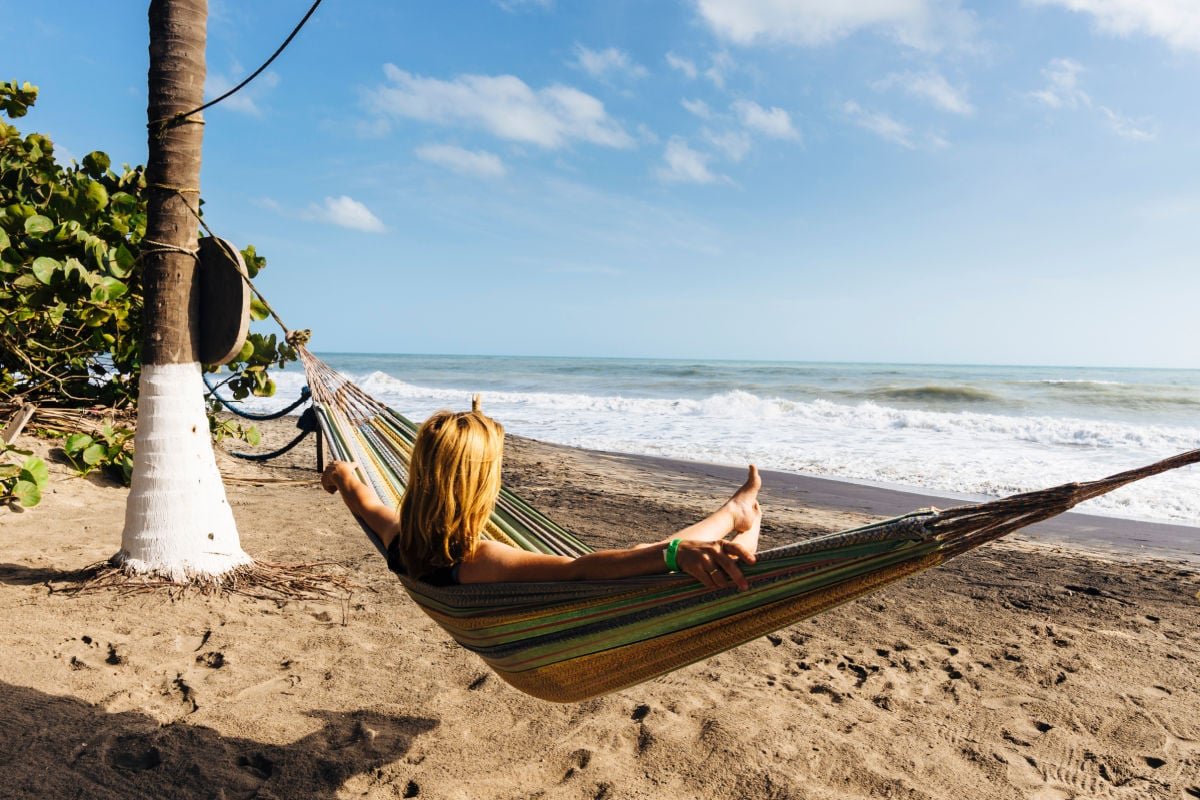 tourist enjoys the sun and sea in a hammock on the Caribbean coast of Colombia